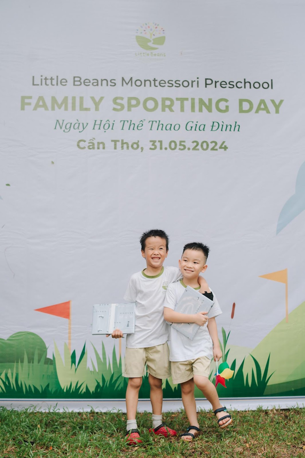 A couple of boys standing in front of a banner

Description automatically generated