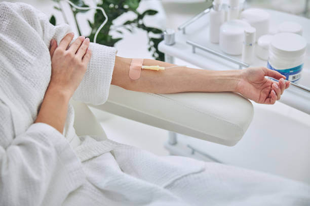 A patient comfortably seated in a wellness clinic, receiving NAD+ IV therapy through an intravenous drip, surrounded by a calming, professional setting.