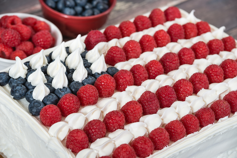 Flag cake decorated with raspberries, blueberries, and frosting