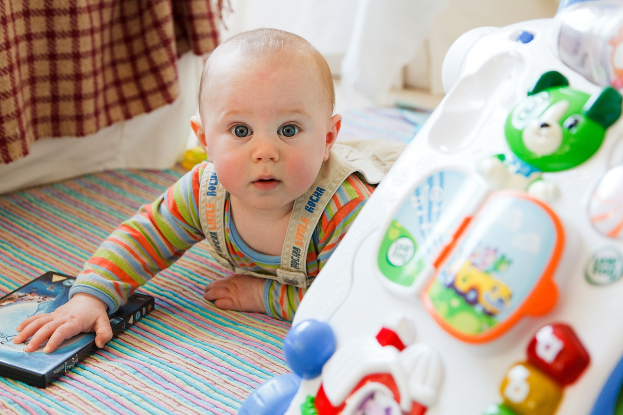 Baby doing tummy time next to bright colored toys