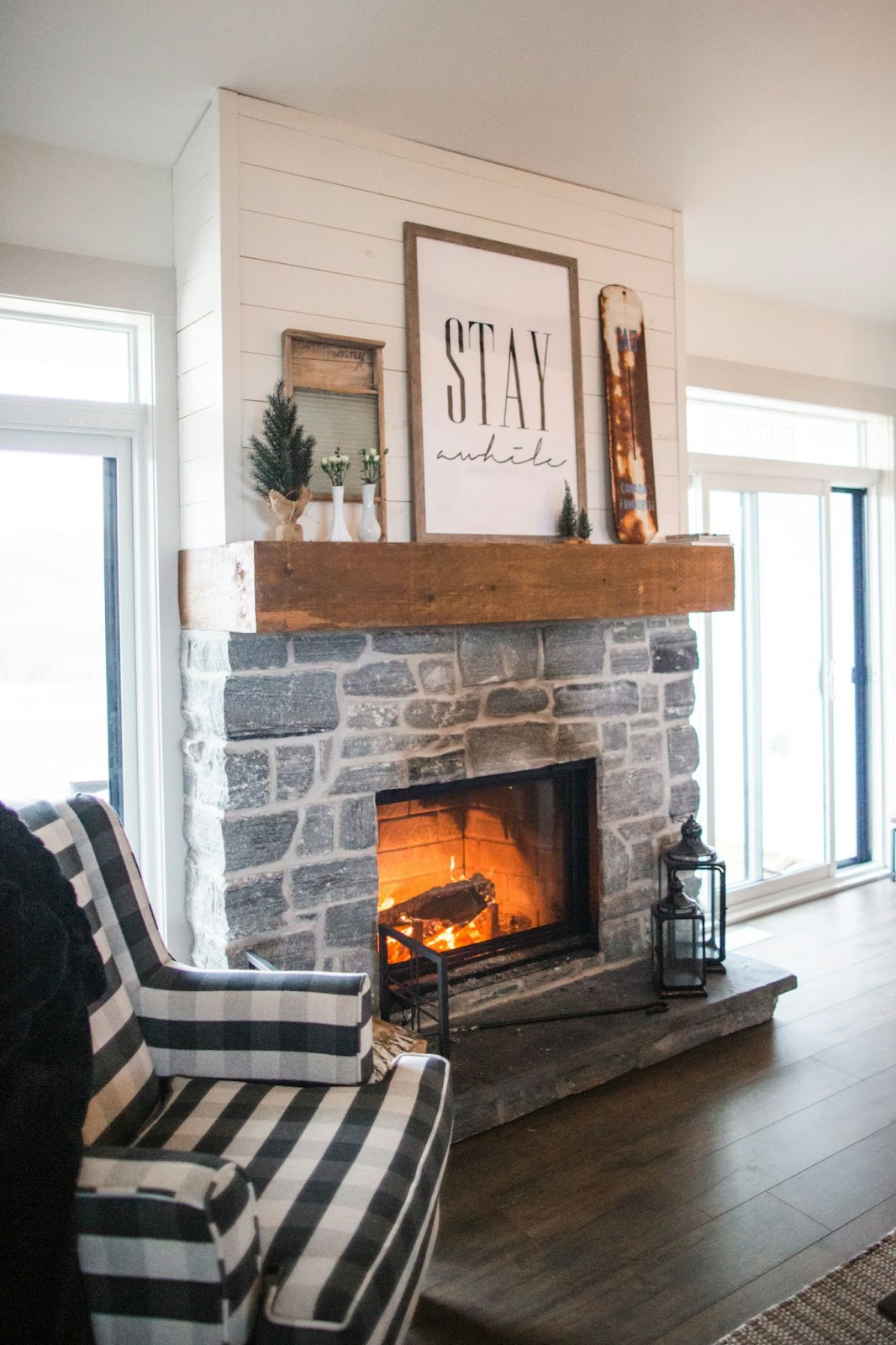 A rustic stone fireplace with burn stains and an armchair close by