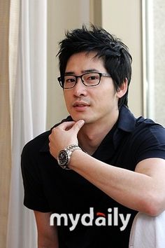 This contains an image of: KANG JI HWAN on black outfit and his hand on his chin 