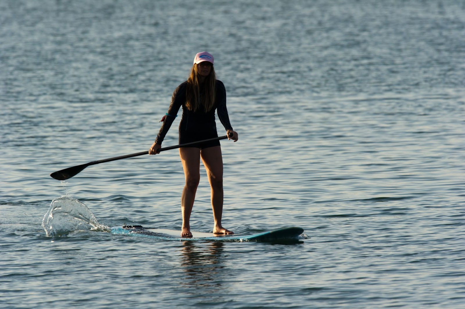 A girl doing Stand-Up Paddleboarding.