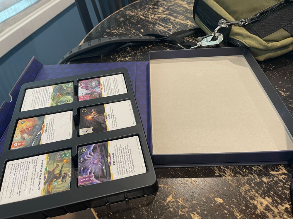 That same box, except the insert holding the cards is demonstrated as coming out, leaving a big empty space behind where one might put dice, pencils and character sheets, as God intended. 