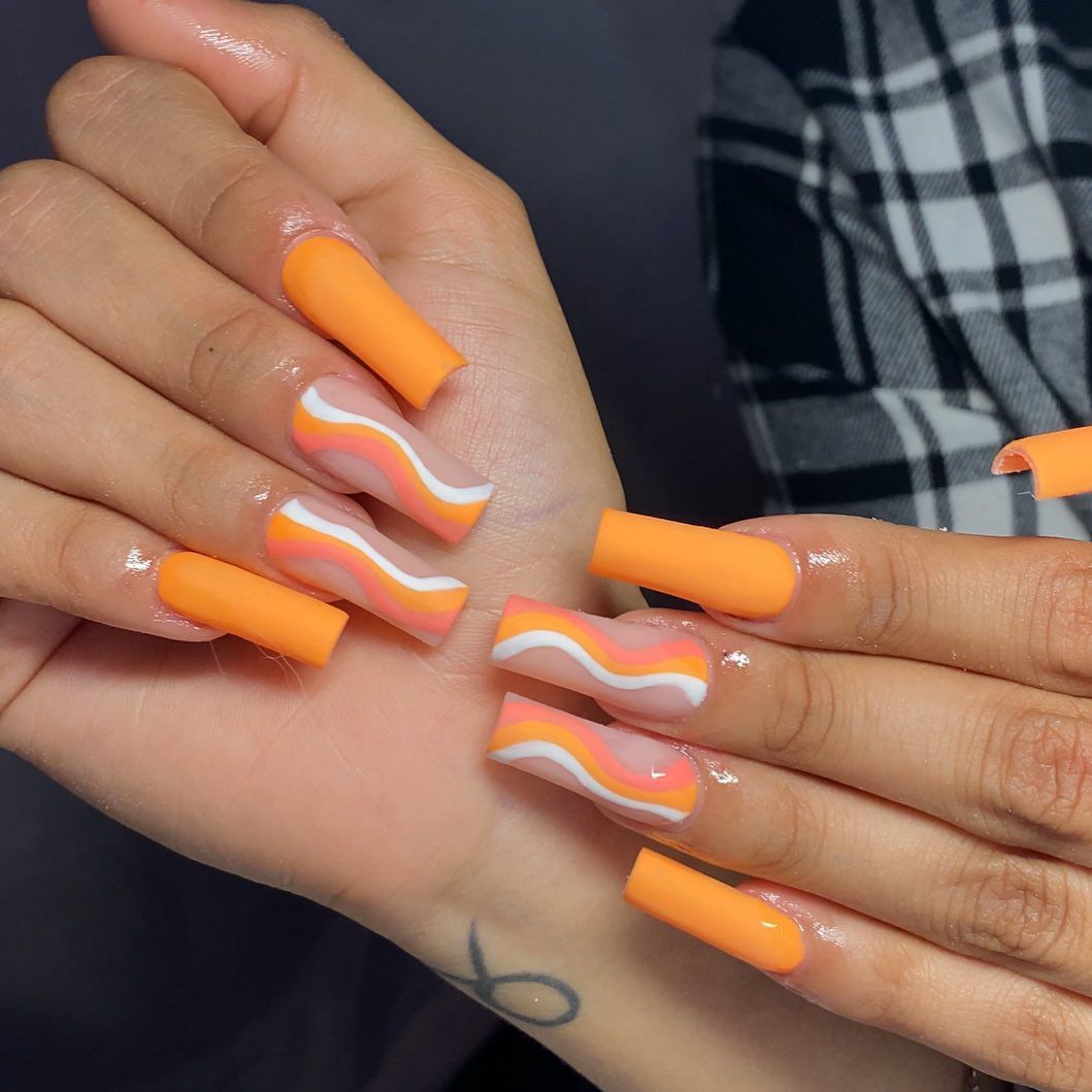 Close up of nails with glittery orange nails having Orange Line Art