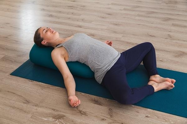 A person lying on a yoga mat
Description automatically generated