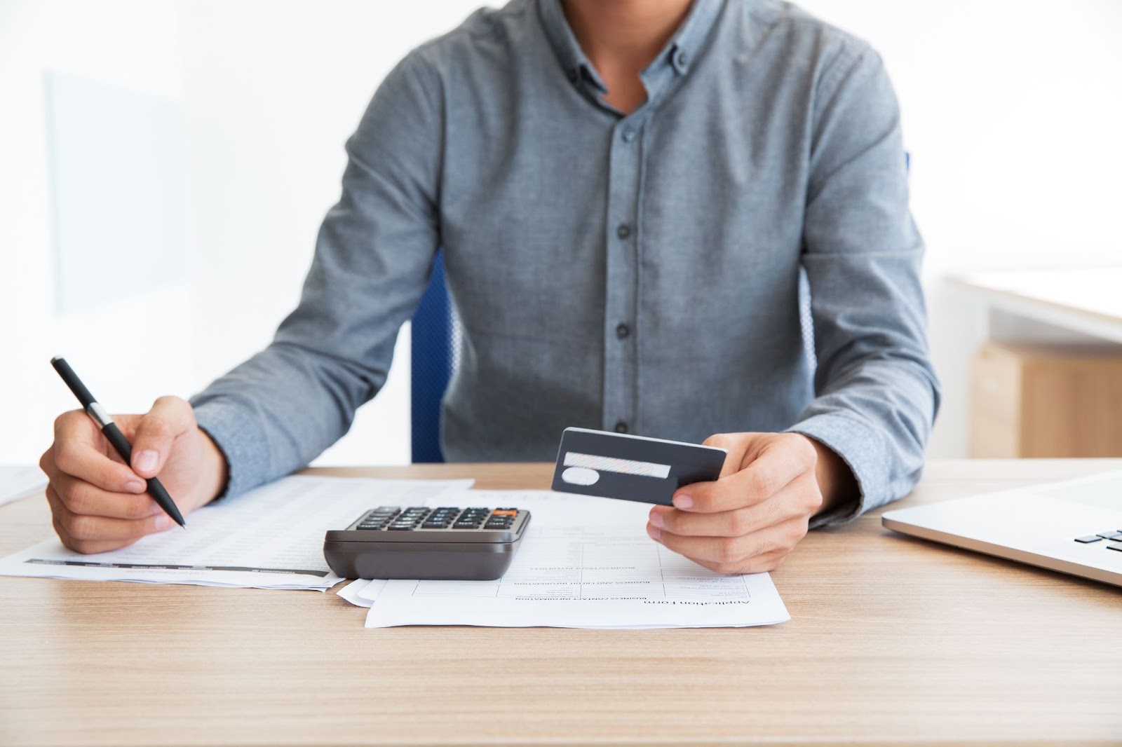 Hombre revisando pagos con tarjeta, gestionando títulos y operaciones de crédito de manera eficiente