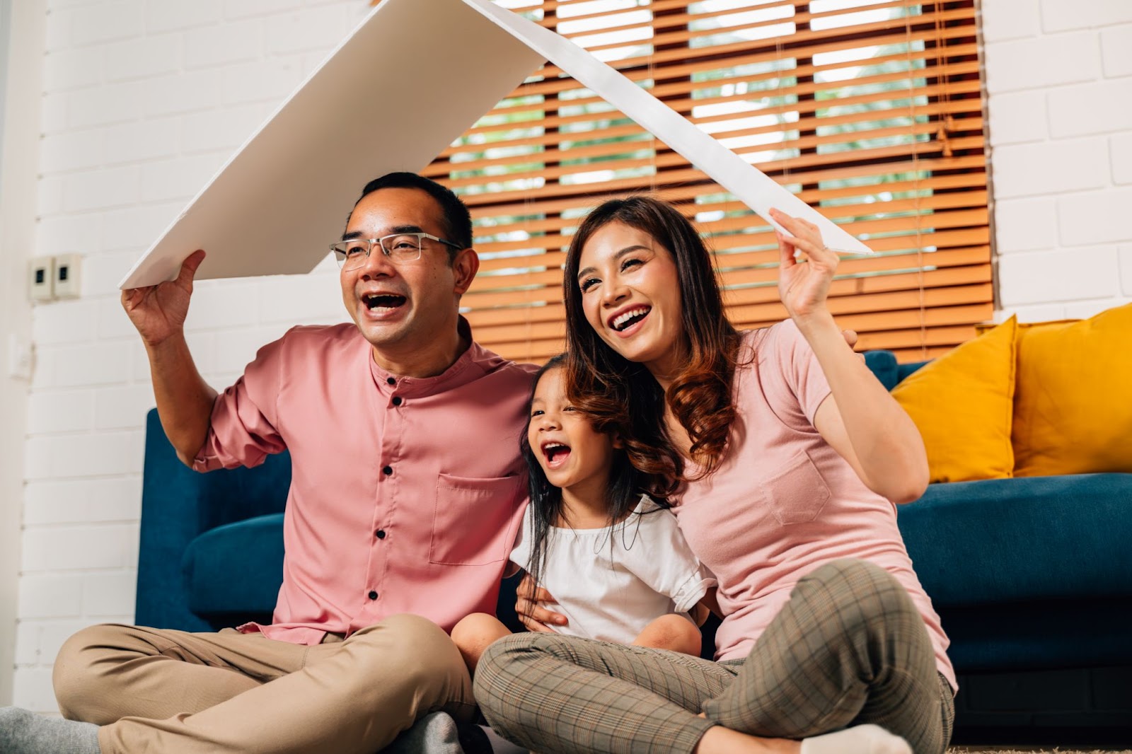 Família feliz segurando o teto simbólico de papelão do seguro de vida