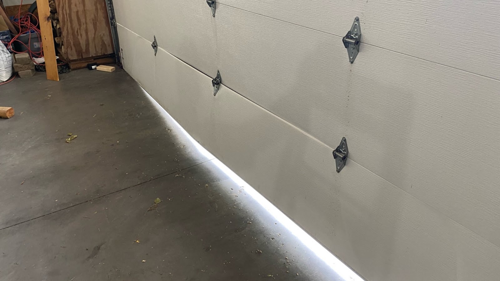Light seeping through the bottom of a garage door requires a bottom seal and panel replacement.