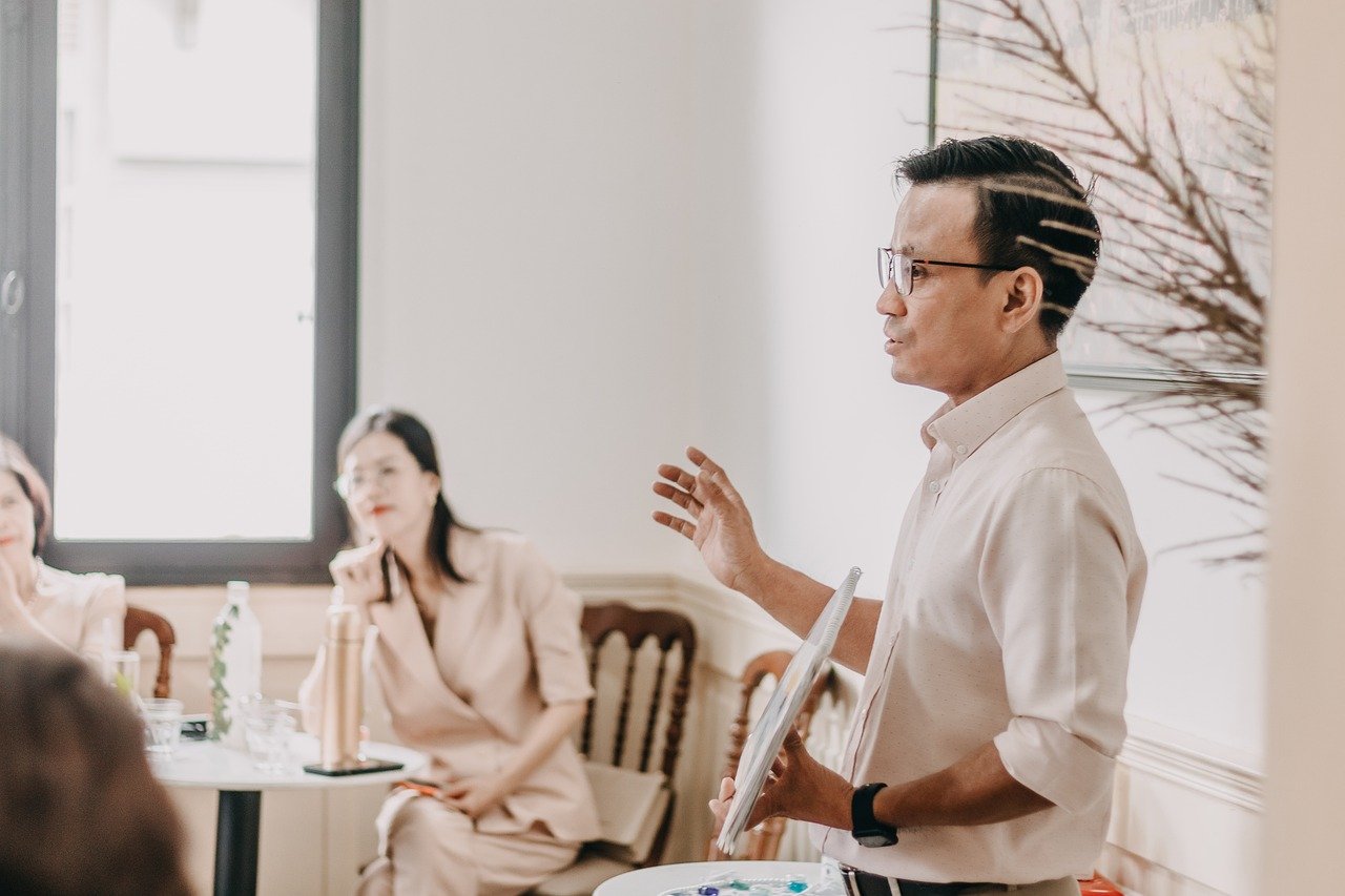 Asian man speaking to a group of people leading boldly. Fix and Form Strategic Branding Agency Denver, CO