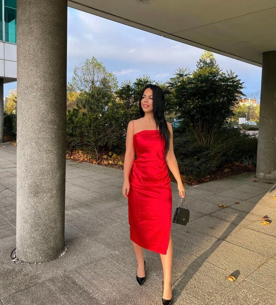 A woman wearing a red satin dress.