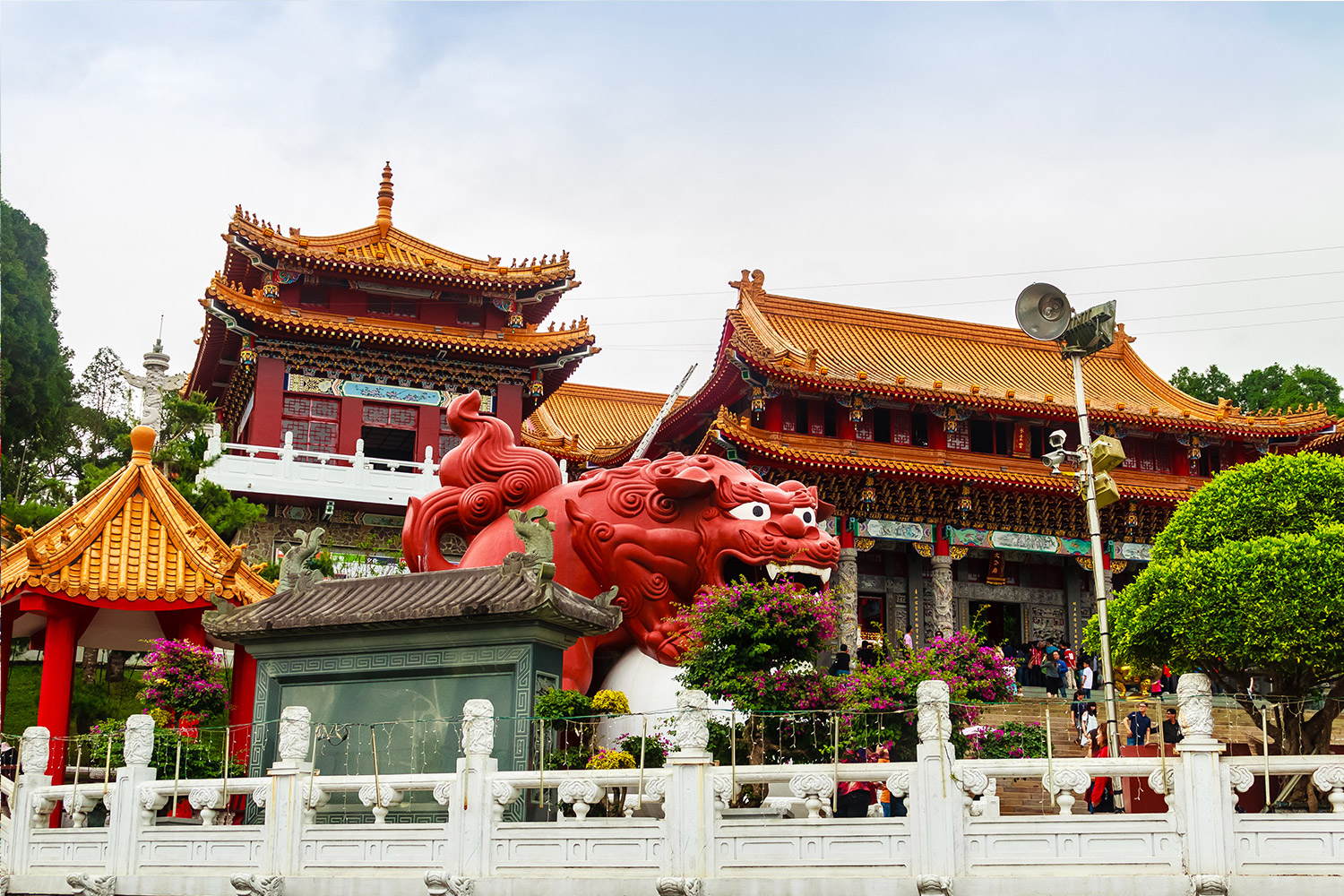 A red dragon statue in front of a building  Description automatically generated