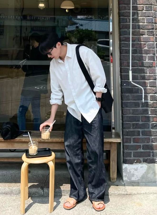Pria mengenakan Korean Style outfit kemeja putih dan celana jeans hitam.