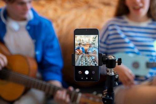 Teenage boy and girl recording music at their home studio with guitar