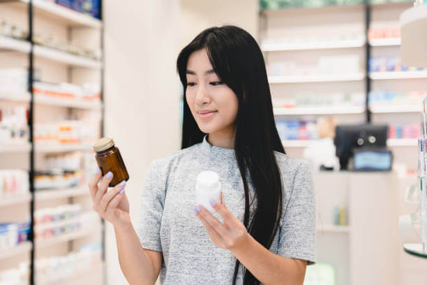 A woman examining supplement labels for bloating relief, carefully selecting a natural remedy.