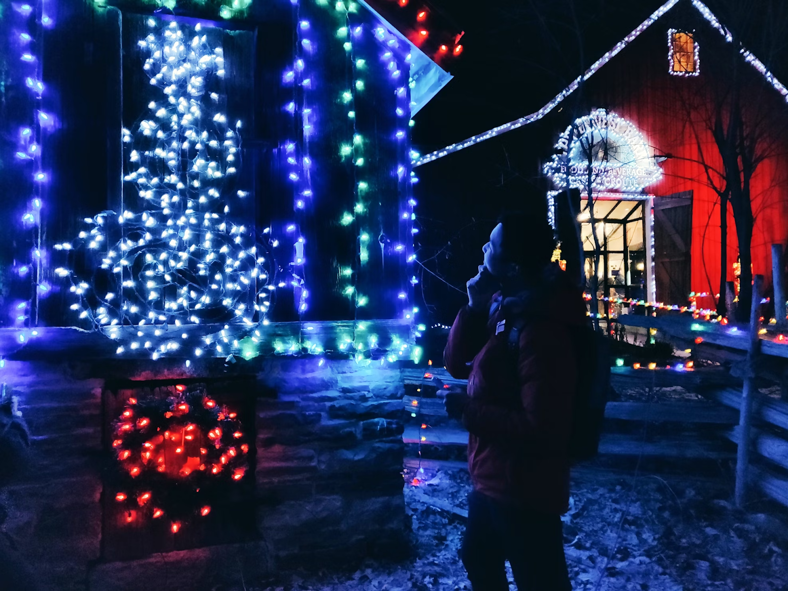 Man admiring Christmas lights hung on a house during the Christmas season.