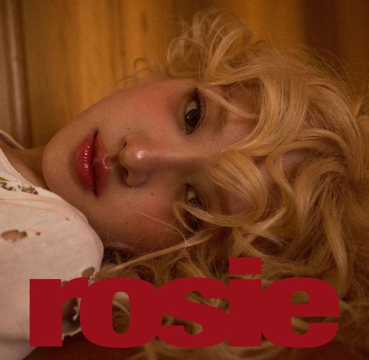 This contains an image of Rosé laying on top of a wooden floor next to a red rose sign with the word rose