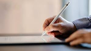 Image contains a writing professional holding a pen.