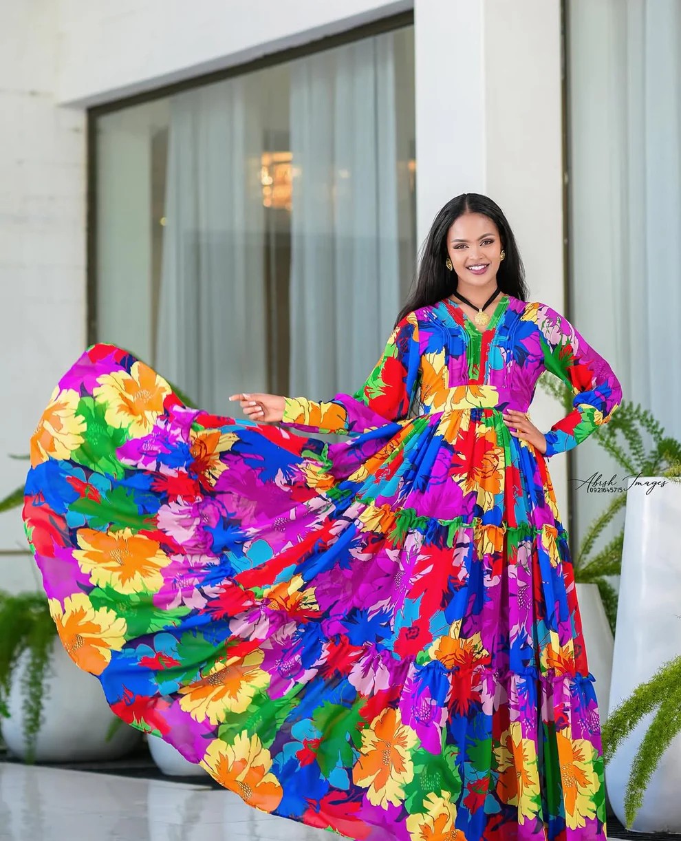 Woman in vibrant multicoloured Habesha dress, chiffon, with floral patterns