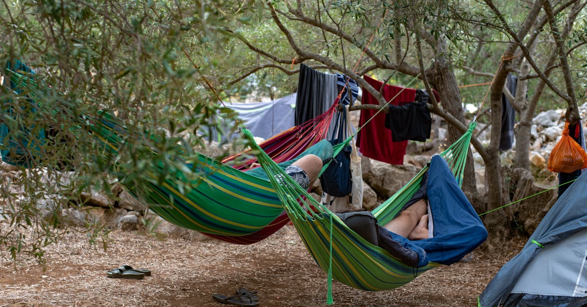 Two campers relaxing in hammocks amidst trees at Lastovo campsite, Croatia.