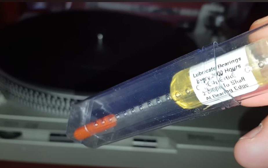 A syringe-like tool used for lubricating bearings on a turntable.







