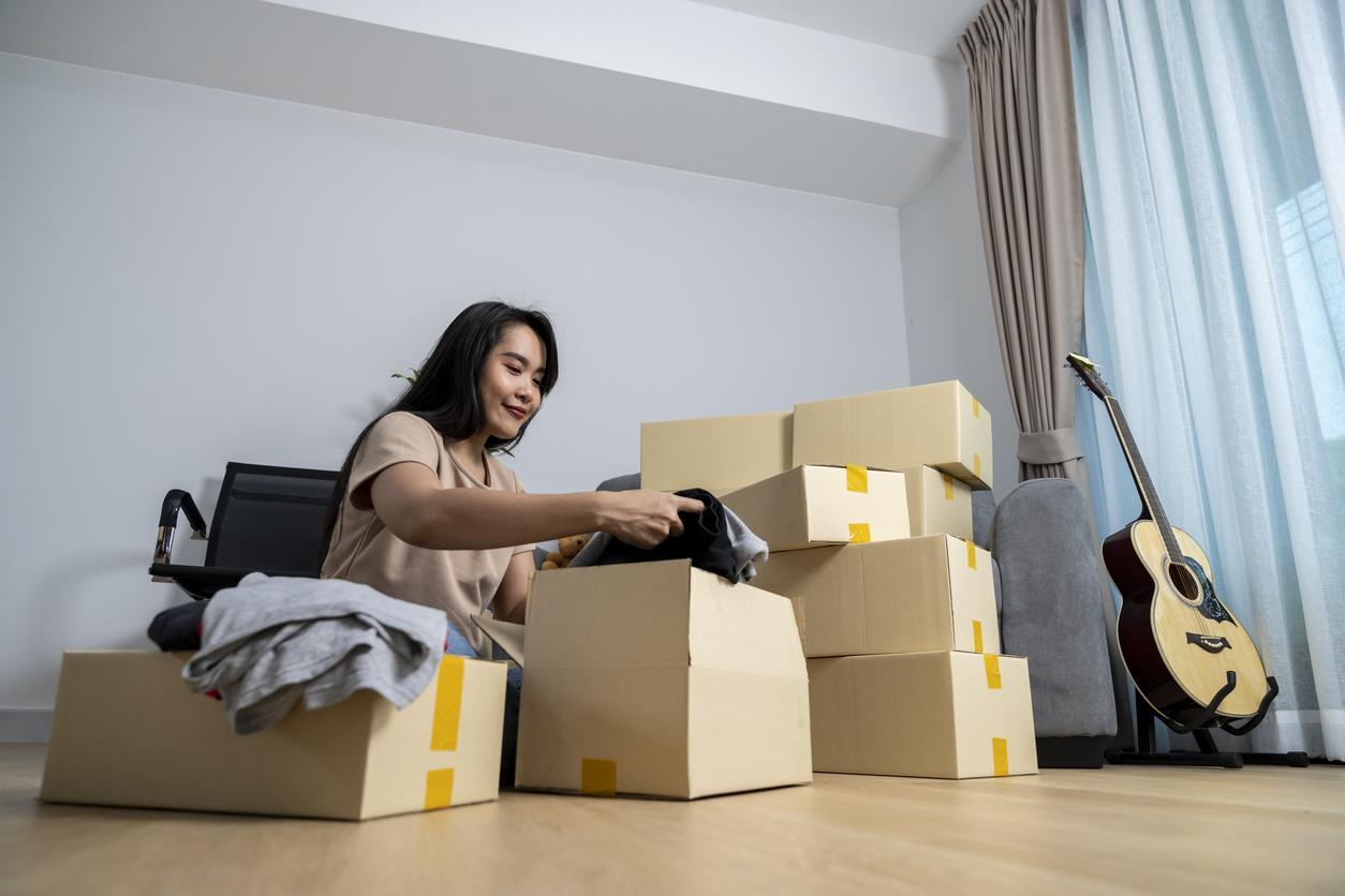 A young woman packs up her belongings in preparation for her move. 