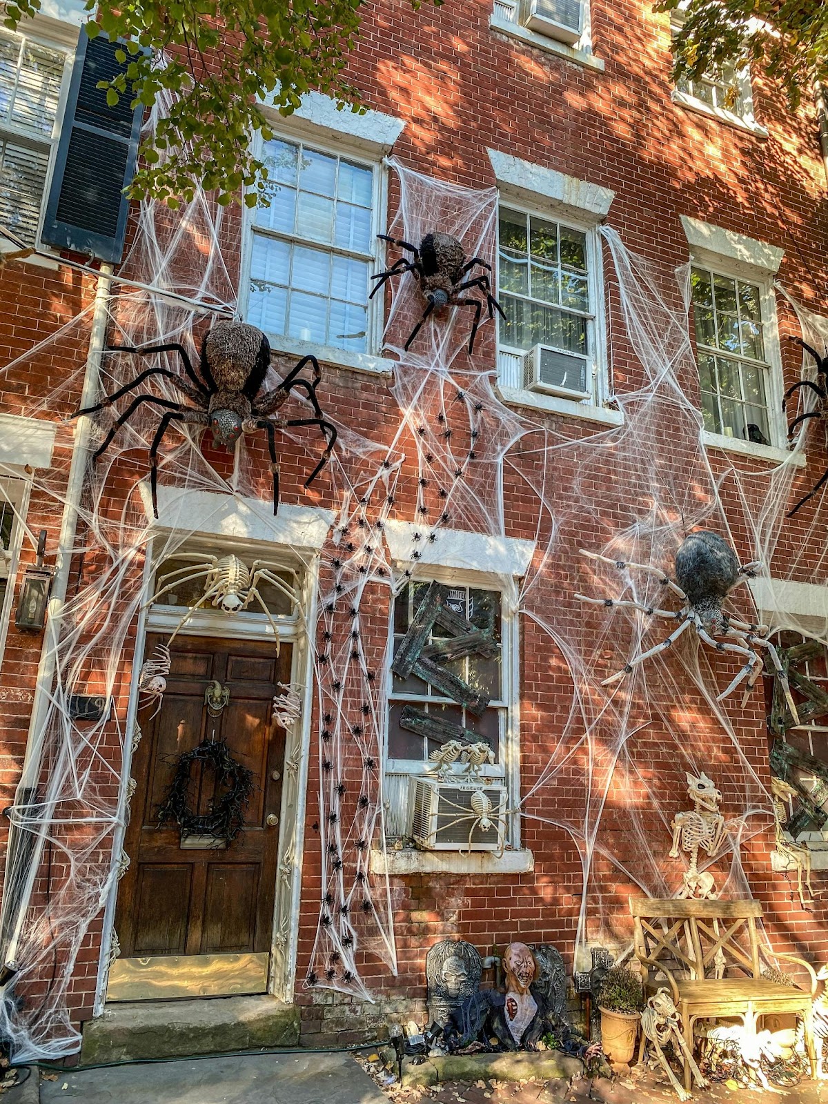 Brick house covered in fake cobwebs and spider decorations