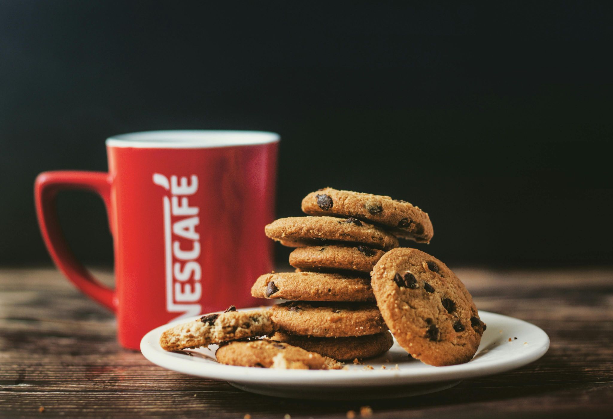 Nestlé stock analysis 2025 with Nescafé cup and Nestlé chocolate chip cookies. Recession-proof investment opportunity.