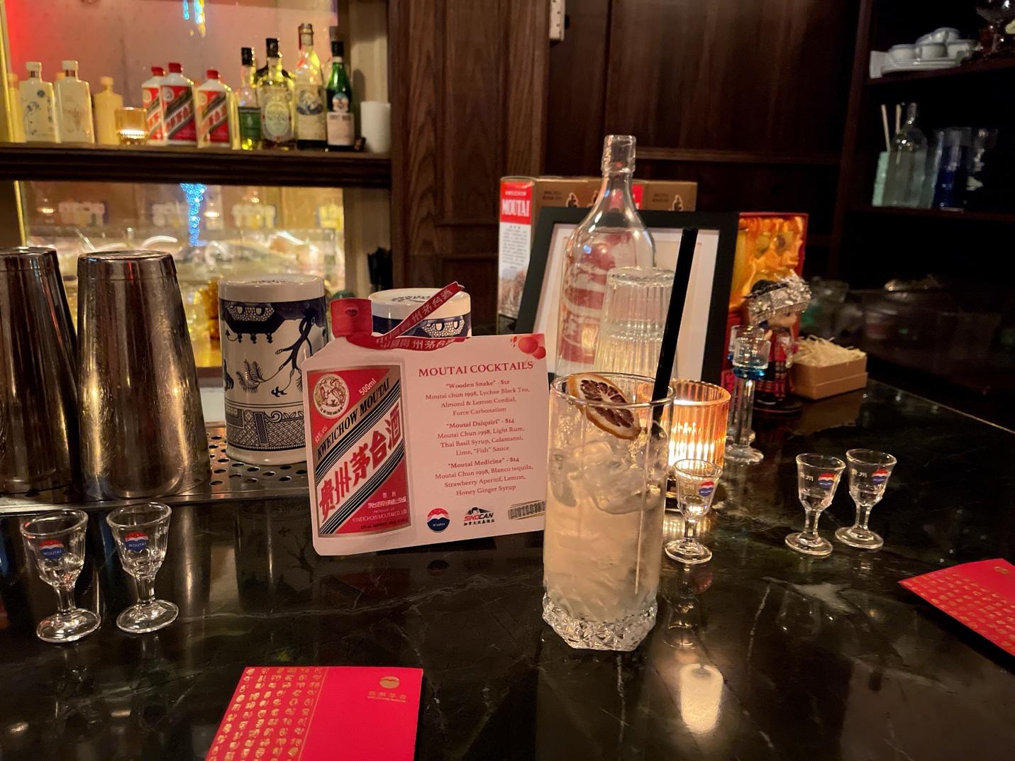 A bar with glasses and a drink on a table

AI-generated content may be incorrect.