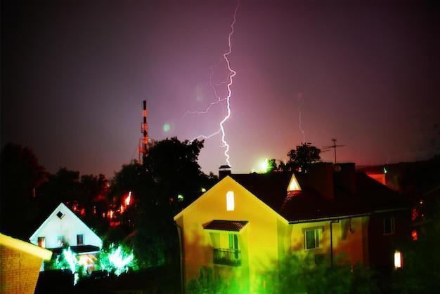 In the night a powerful bolt of lightning hits a house amid a thunderstorm