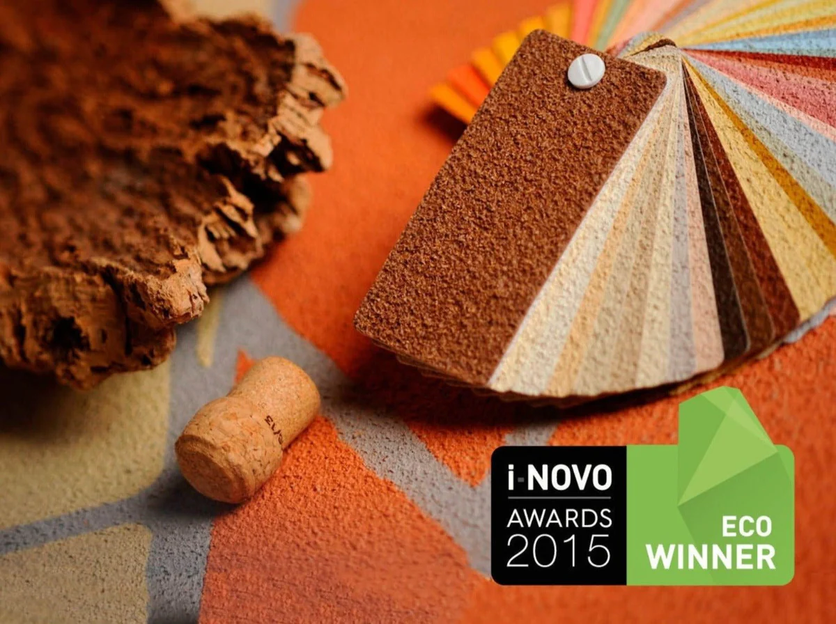 A selection of cork paint samples in various vibrant colors sits next to a wine cork and raw cork bark.