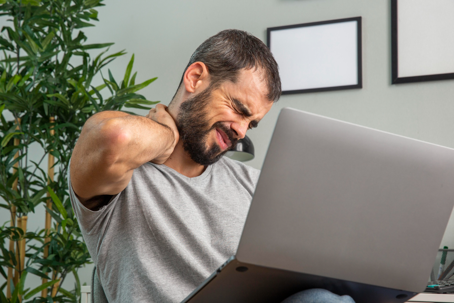 A person experiencing neck pain, a result of poor static loading ergonomics.
