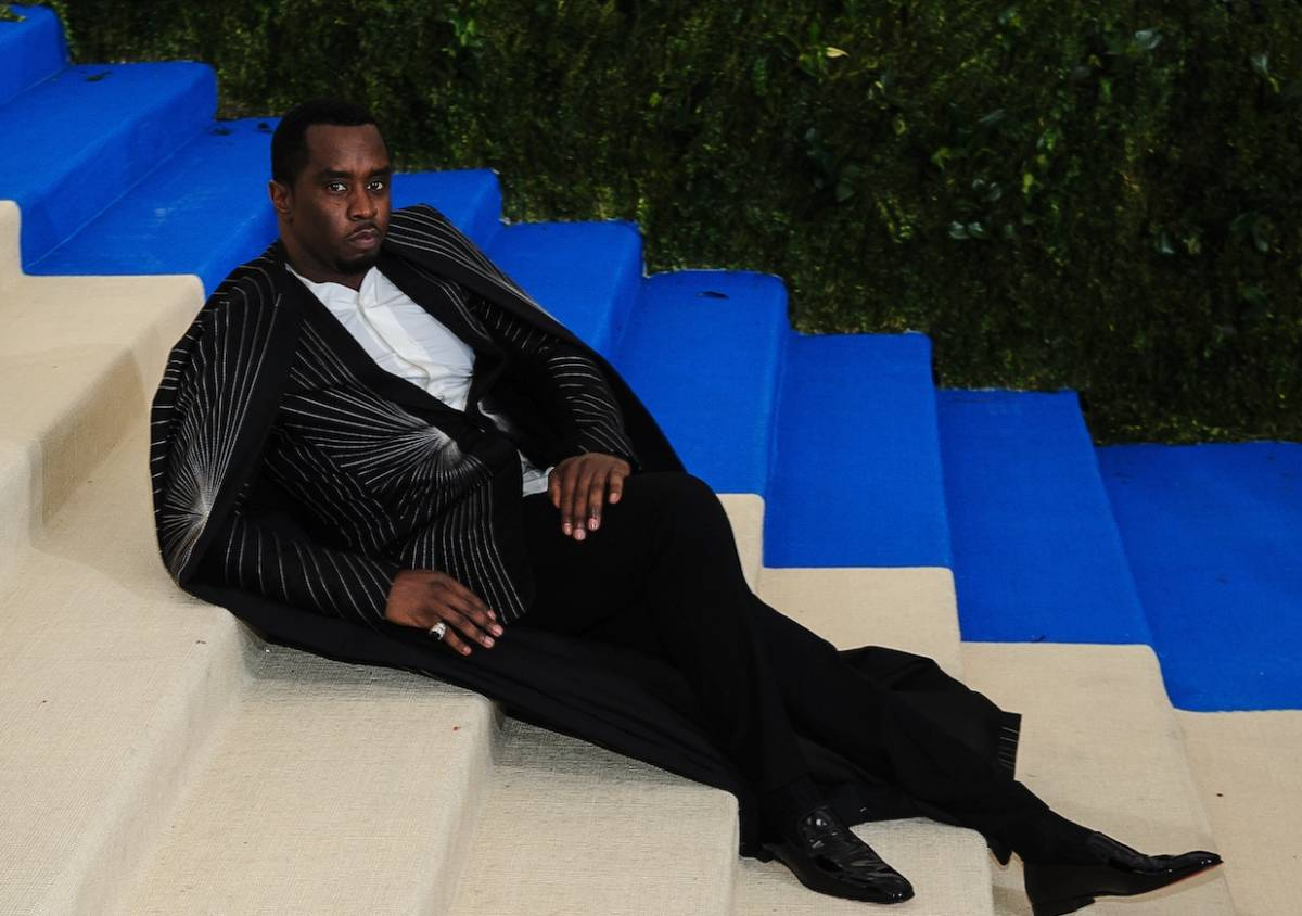 Sean Combs aka Diddy reclines on a staircase wearing a suit