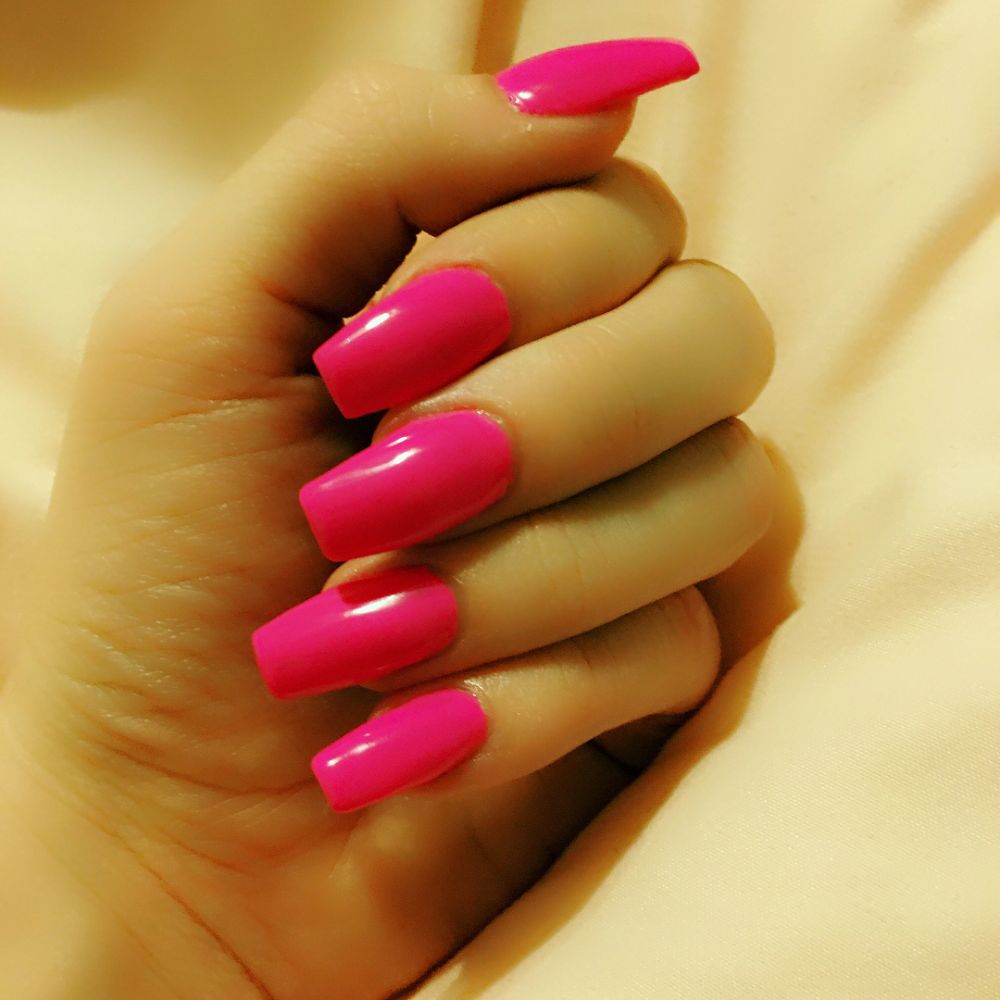 Close up of nails with simple pink nail designs having Hot Pink Coffin Nails