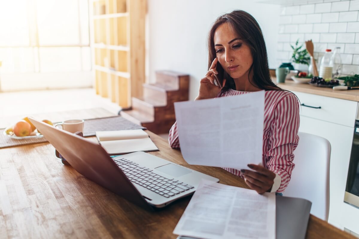 Claims intake process: employee talking on the phone while reading a document
