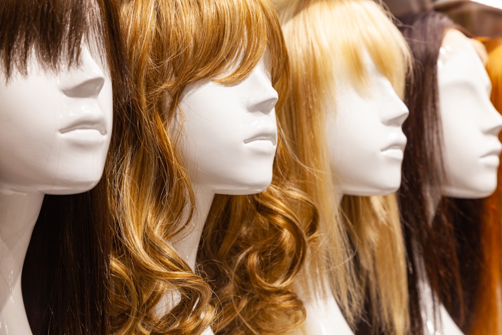 Multicolored wigs on mannequins