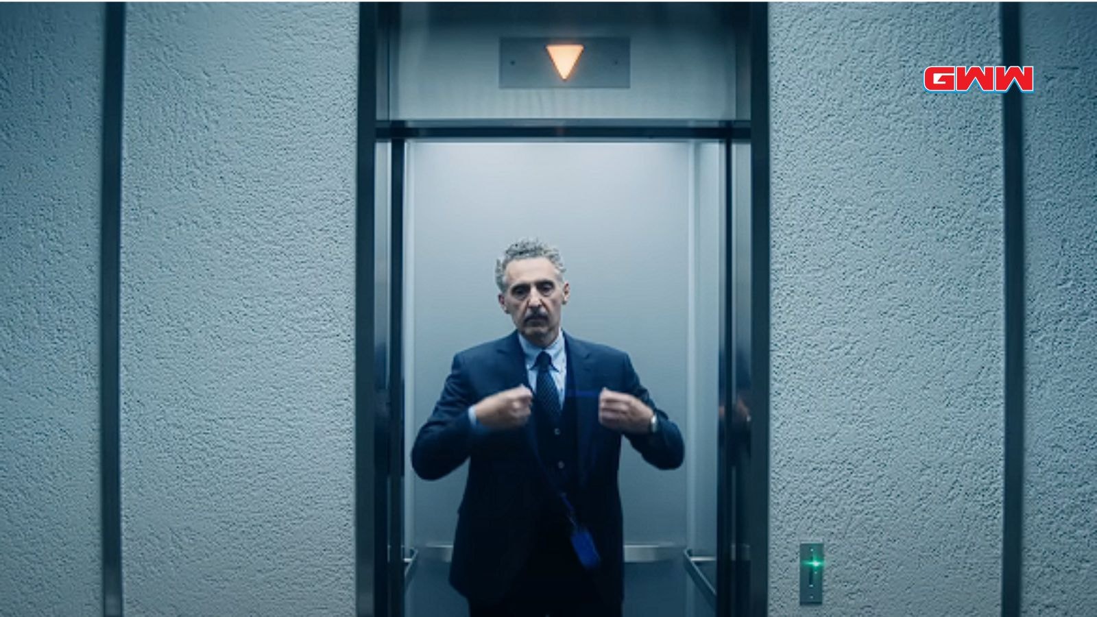  Irving, adjusting his tie, in an elevator from the "Severance" series.