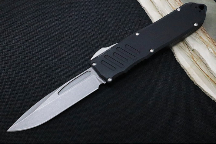 An image showcasing the Guardian Tactical RECON-040 on a solid black and wood background. The knife features a stonewash Elmax blade and a black aluminum handle.