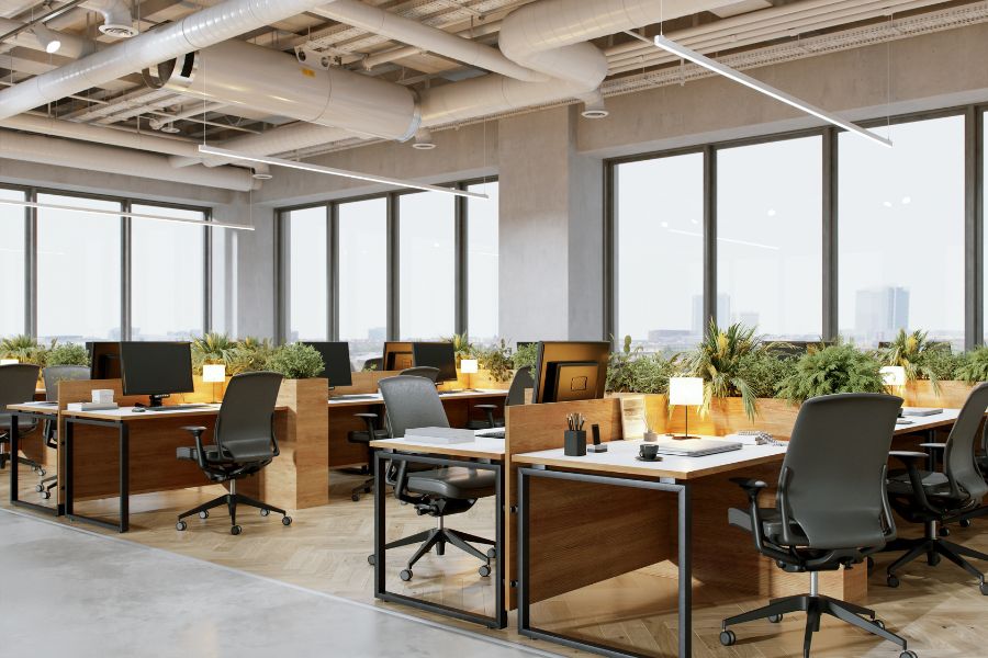 Modern office space with desks, chairs, and large windows.