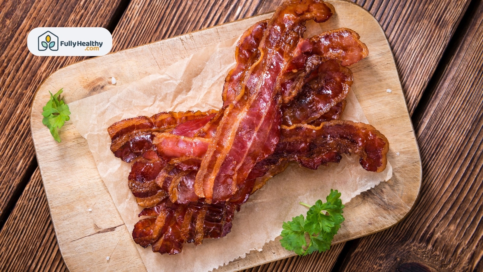 Stack of bacon strips on parchment over wooden board