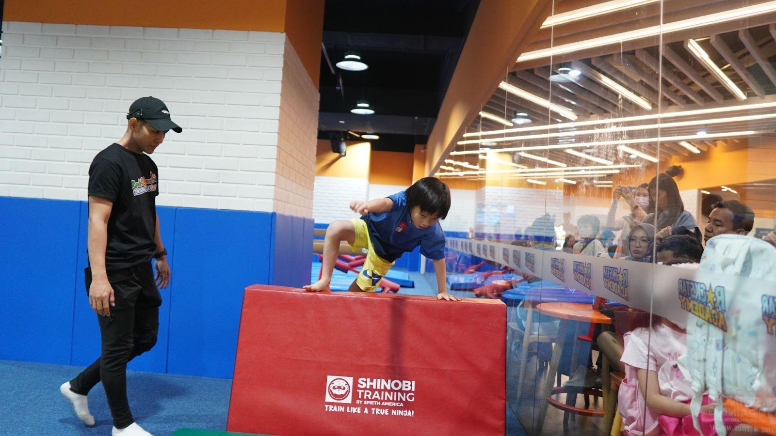 Anak laki-laki dengan kaos biru melakukan vaults
