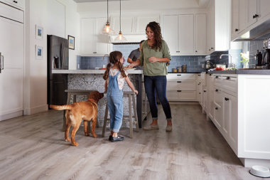 hardwood vs luxury vinyl flooring comparing interior upgrades family in kitchen with lvp floorboards custom built michigan