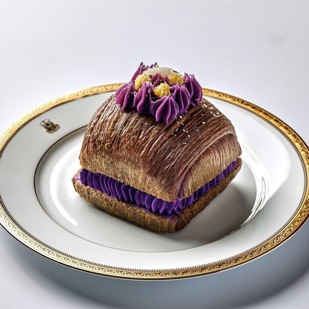 A piece of pastry with purple frosting on topDescription automatically generated