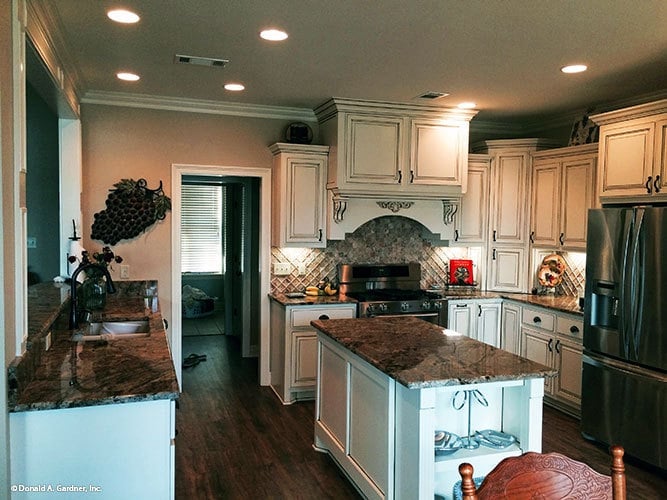 The kitchen offers white cabinetry, stainless steel appliances, granite countertops, and a center island.