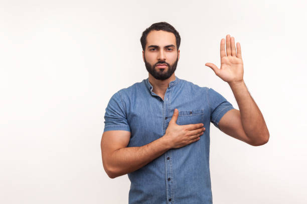 Hispanic man raising his right hand during naturalization oath