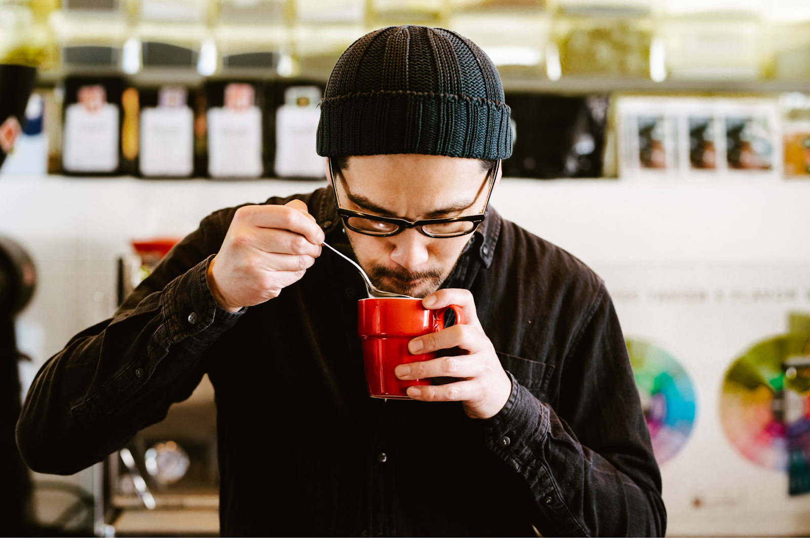 A picture of a man tasting coffee notes using cupping technique