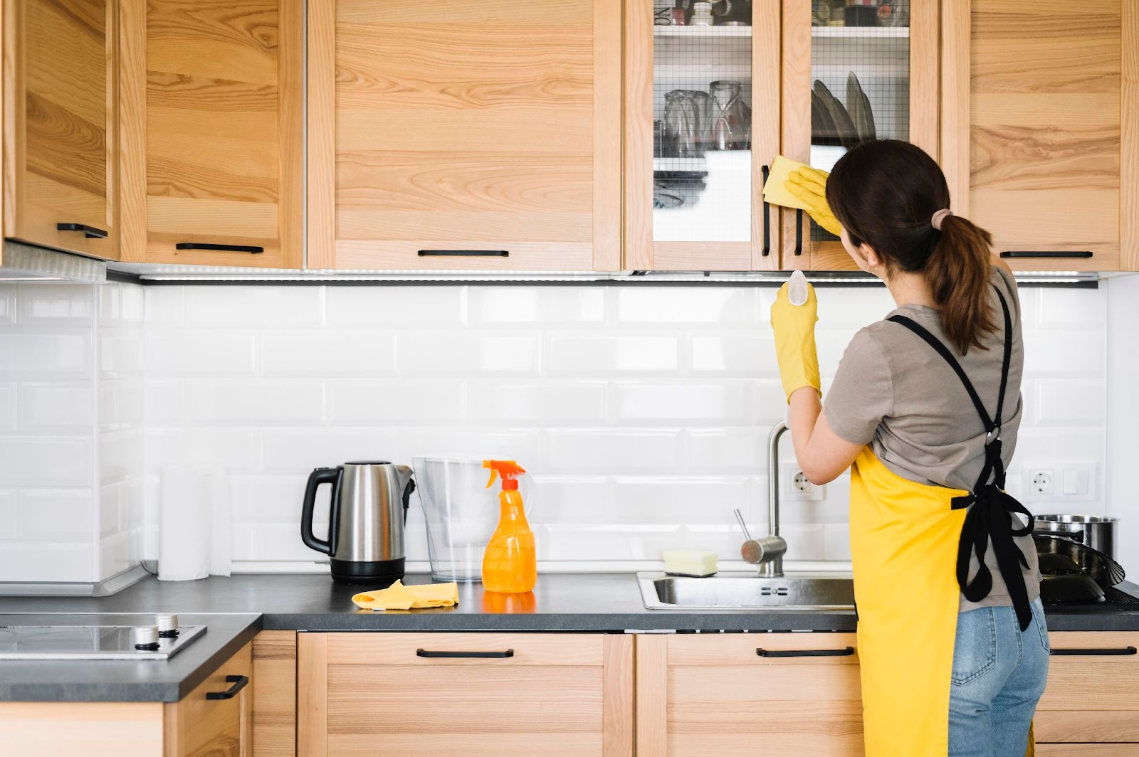 seorang wanita sedang membersihkan rak kabinet dapur