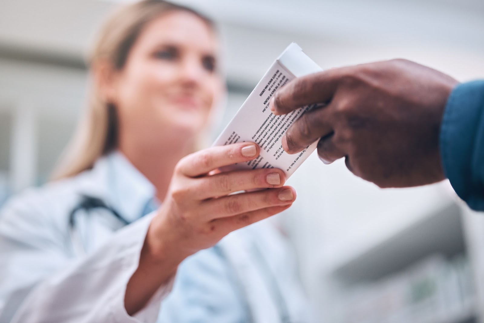 Female doctor handing someone a prescription. 