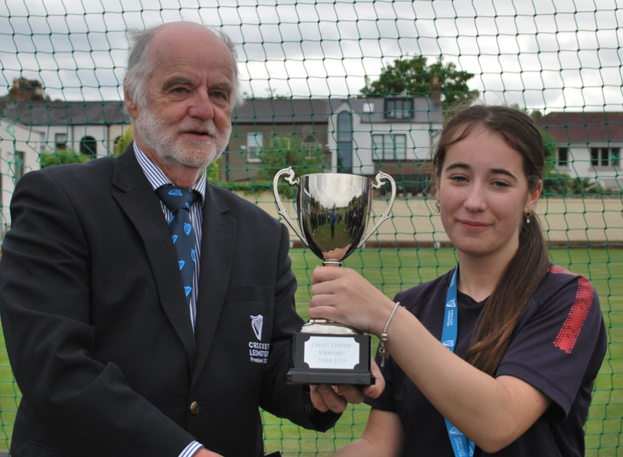 A person and person holding a trophy

Description automatically generated