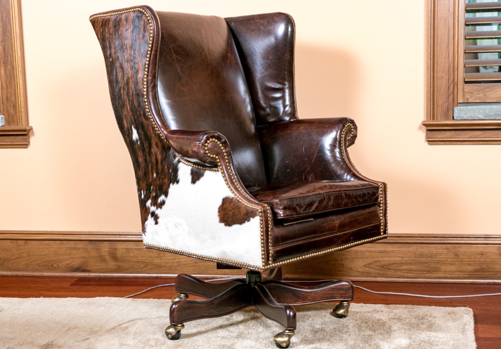 Dark brown leather executive office chair with cowhide sides and caster feet